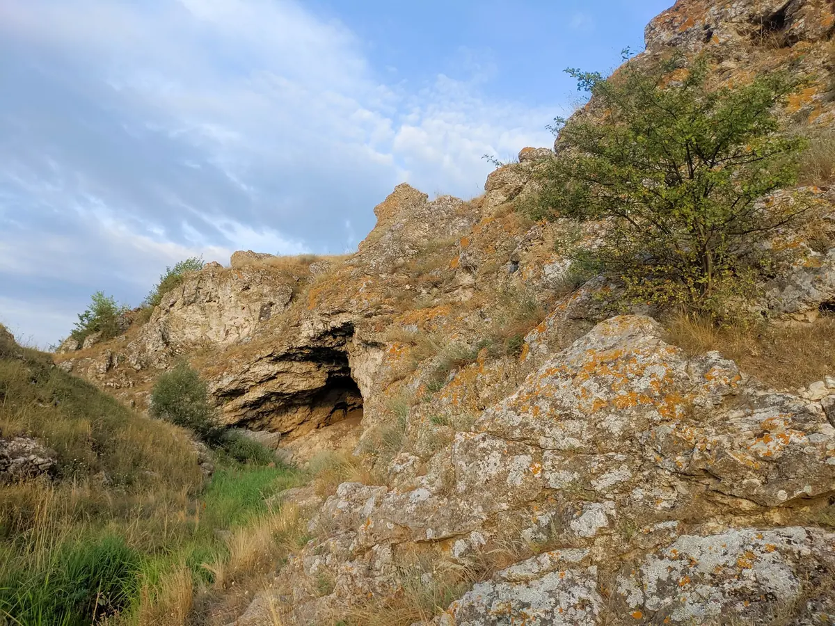 The mouth of a grotto in the limestone wall of the Varatic Gorge