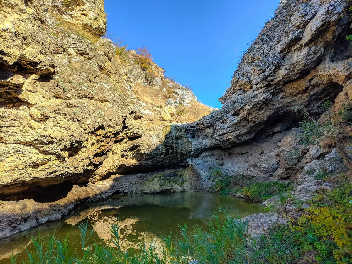 The water gathered at the foot of the waterfall, between the stone walls