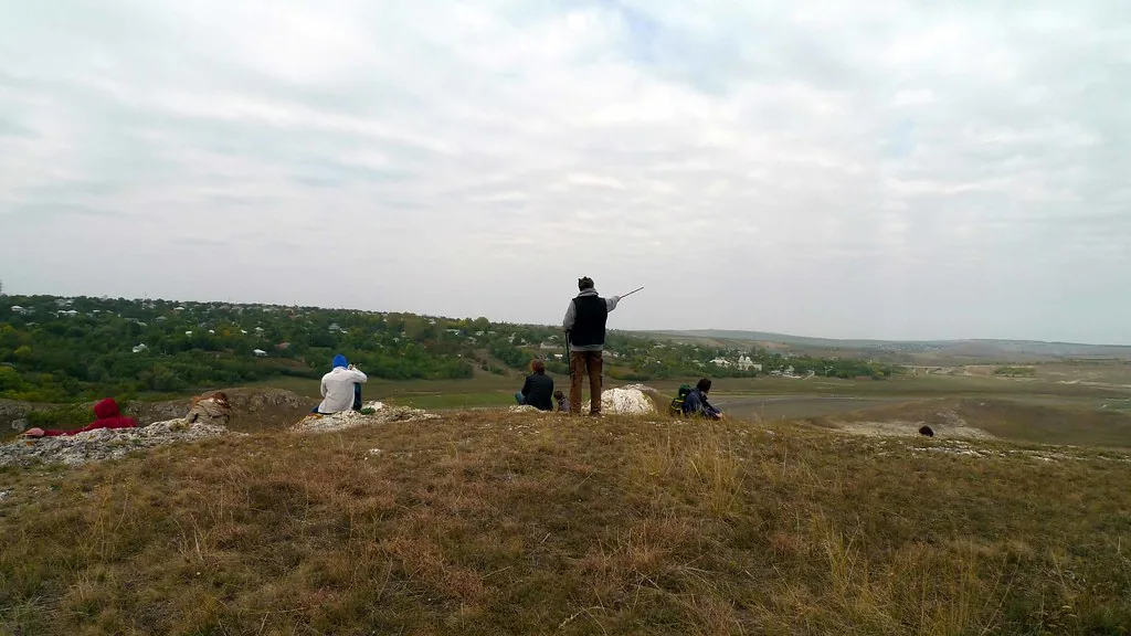 Grup de oameni pe o stâncă, privind spre valea de la Duruitoarea Veche