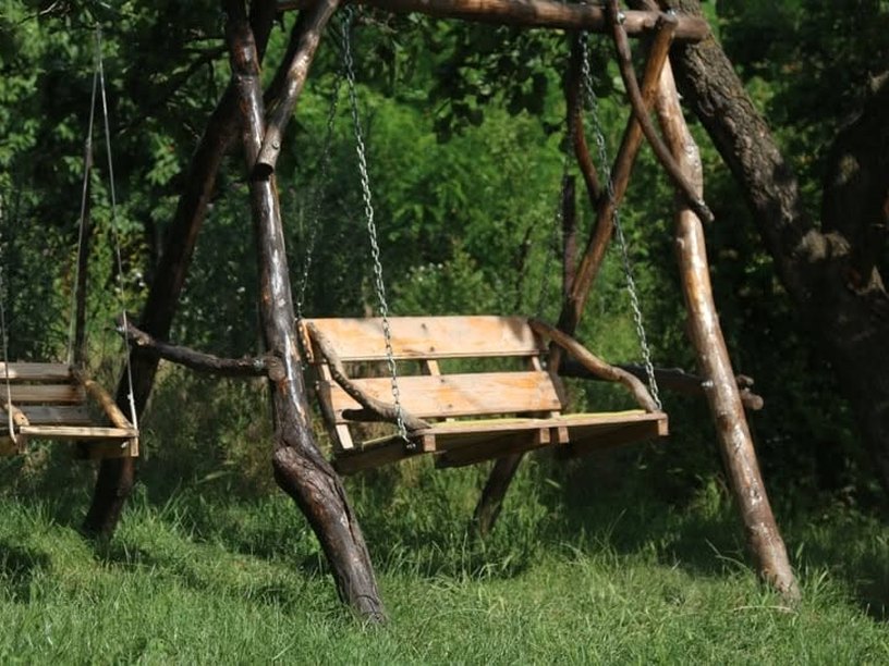 Leagăne de lemn în grădina pensiunii