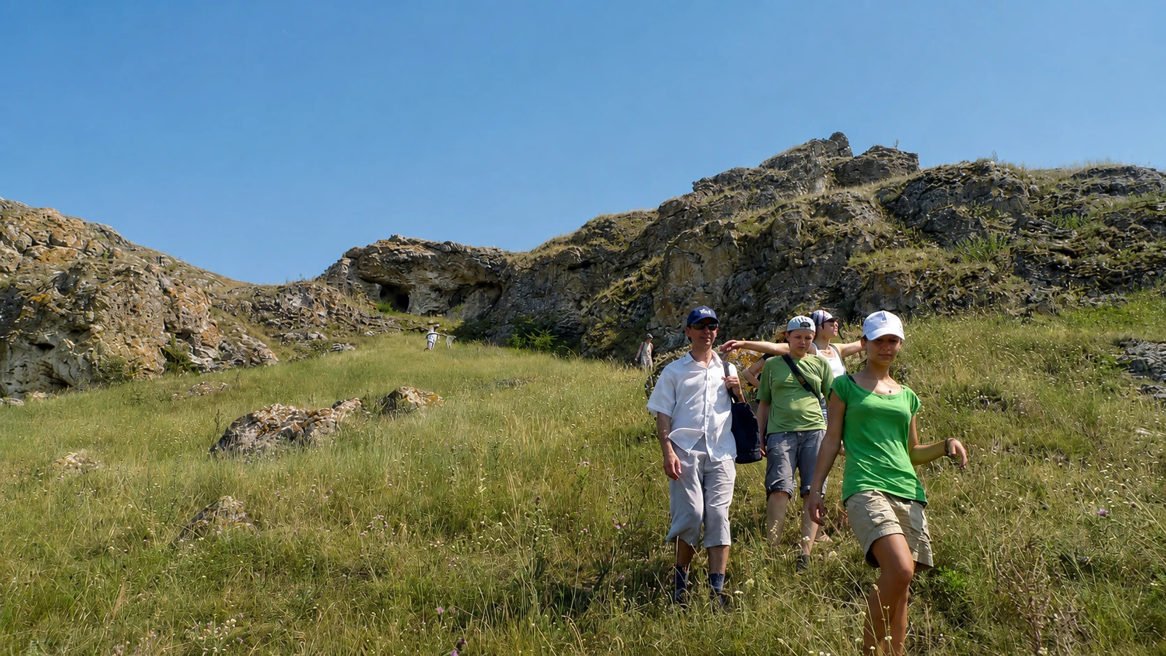 Grup de turiști coborând de la Stânca Dragostei, recif de calcar cu grote